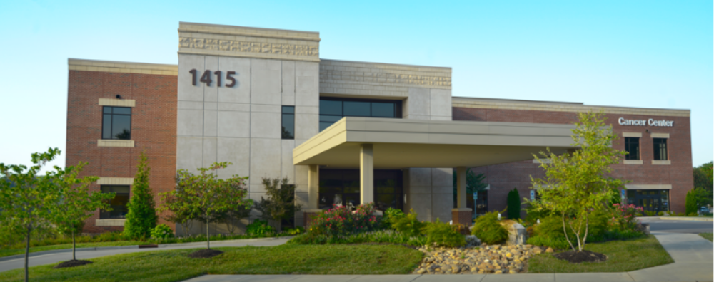Exterior view of the Provision Cancer Center building at 1415, showing the main entrance, landscaped grounds, and patient drop-off area.
