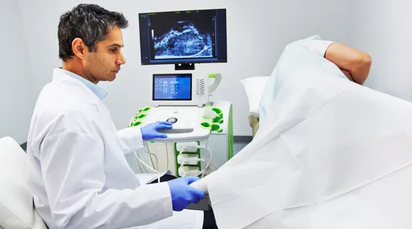 Physician performing a prostate ultrasound procedure with imaging displayed on monitor, illustrating diagnostic testing used in the evaluation of prostate cancer.